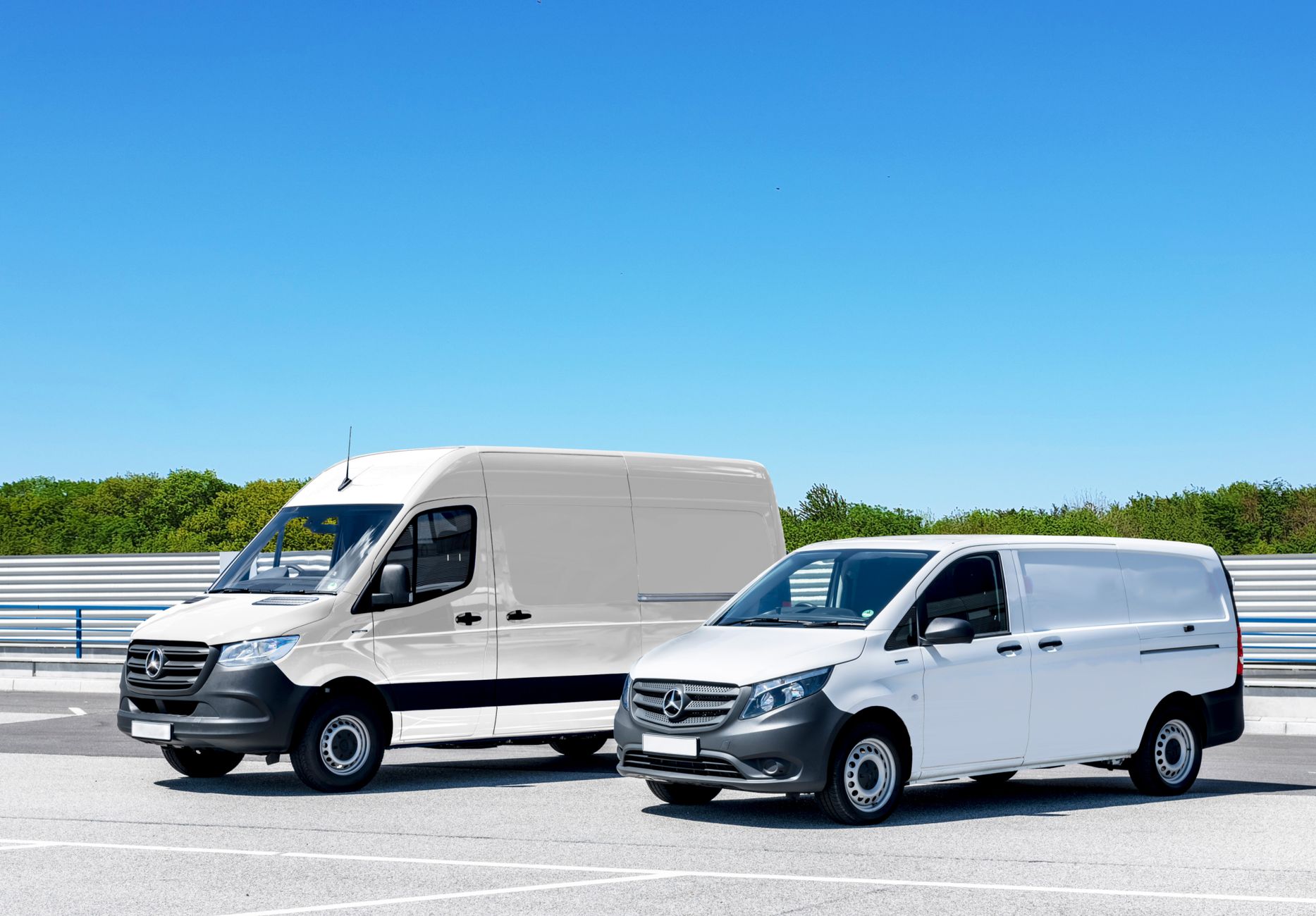 Vans brancas de entrega estacionadas lado a lado sob céu azul
